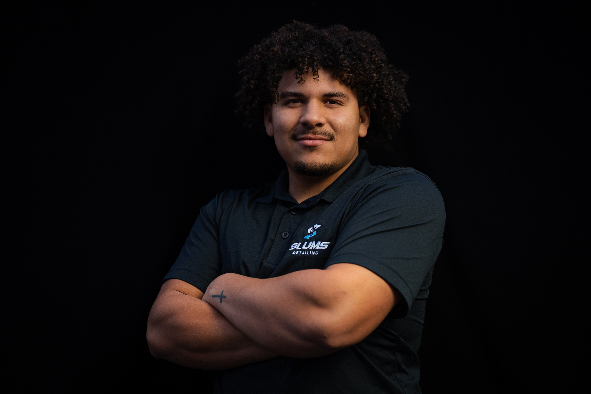 Dominick, owner of Slums Mobile Detailing, in his branded Slums Detailing polo